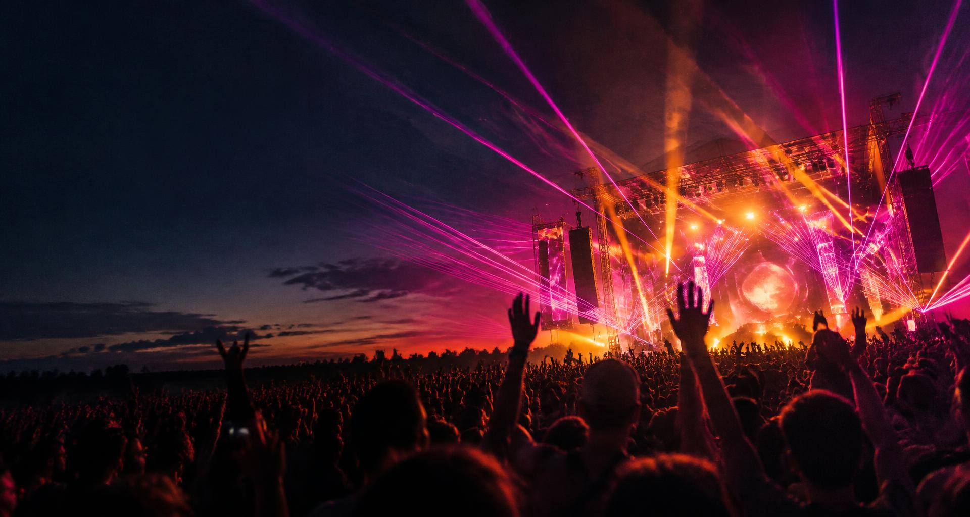 A festival crowd beneath pink lasers and golden stage lights